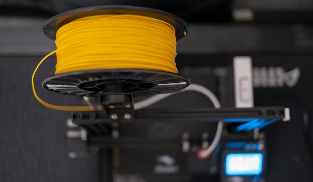 a spool of yellow wire sitting on top of a machine